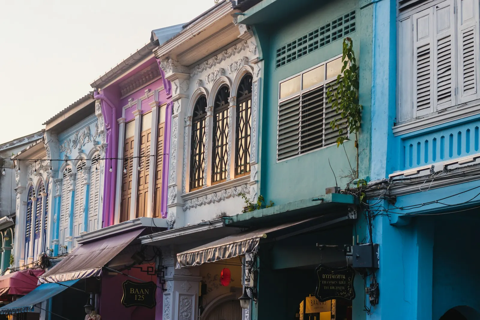 Rangée de shophouses sino-portugaises colorées aux fenêtres cintrées et volets de bois, typiques de la vieille ville de Phuket