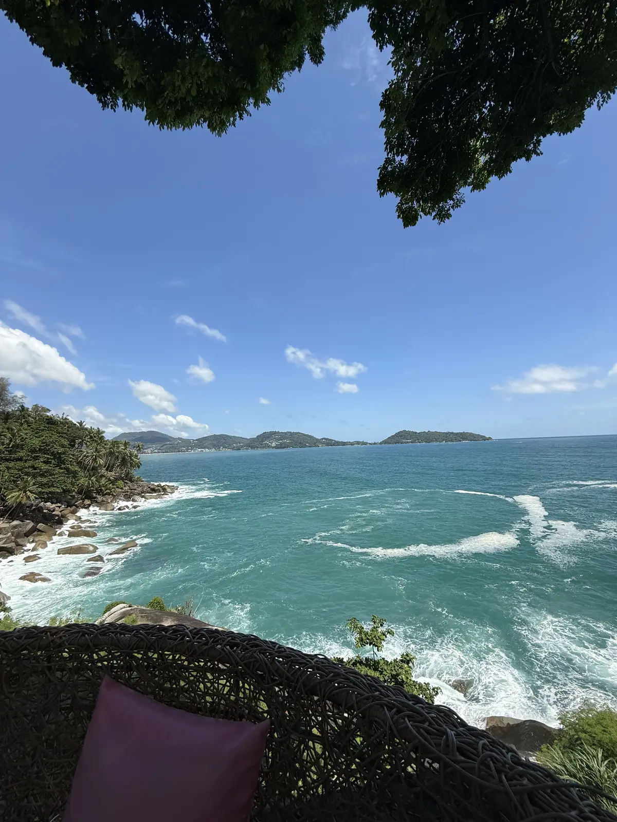 Vue plongeante depuis la colline sur une baie de Phuket, eau turquoise, rochers et bateaux au mouillage