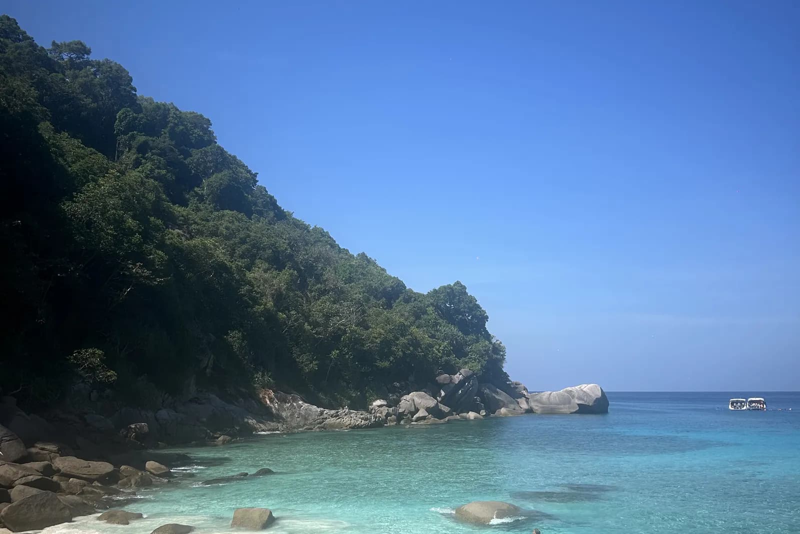 Petite crique de Phuket bordée de rochers, eau turquoise et sable clair