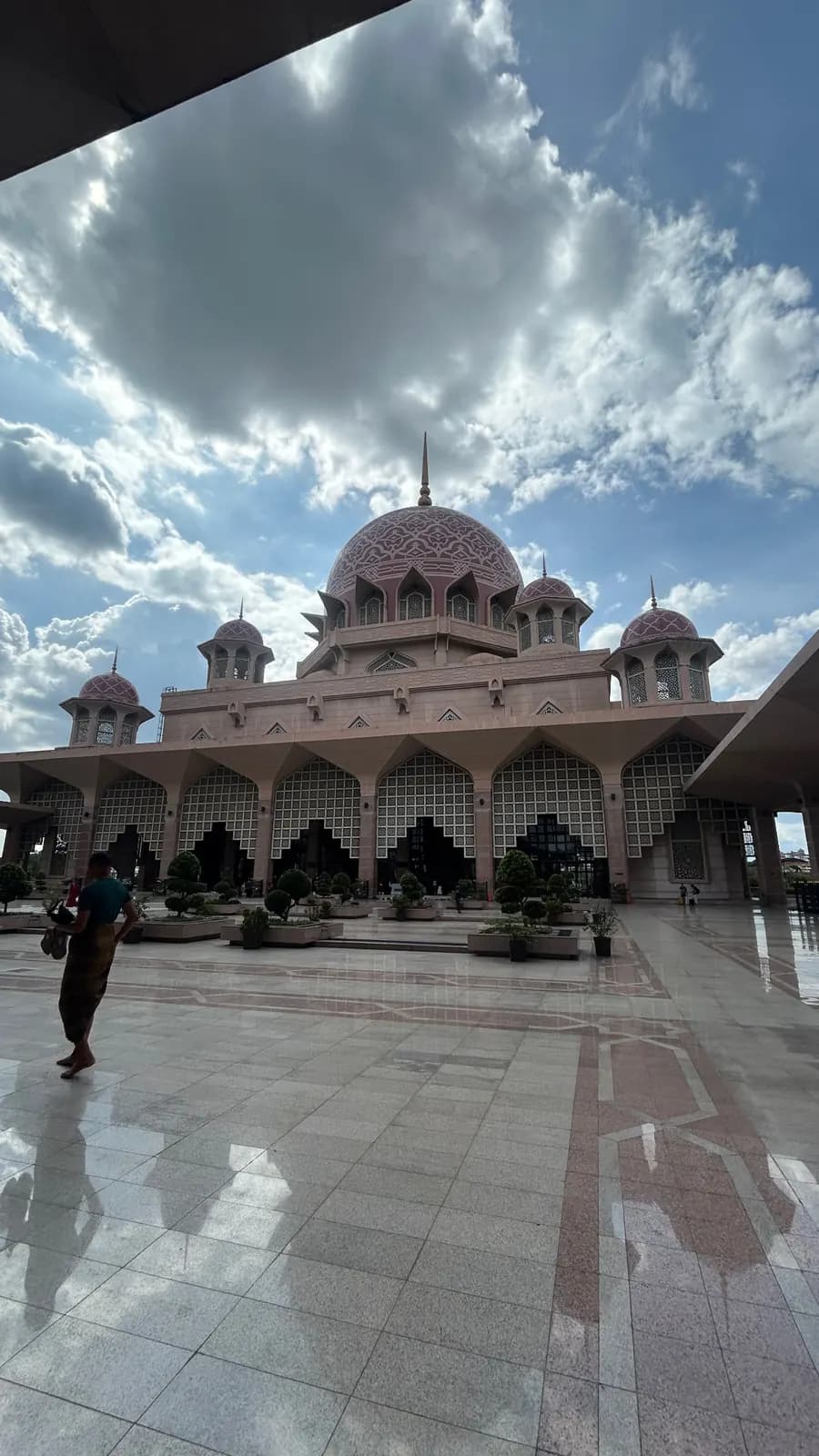 La cour et les dômes roses de la mosquée de Putrajaya sous un ciel chargé