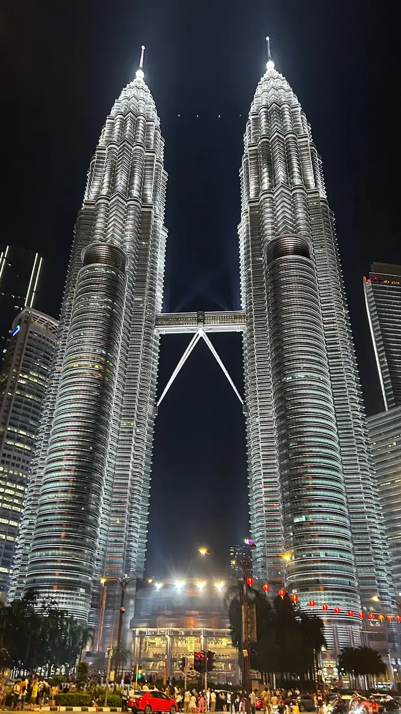 Les tours Petronas illuminées la nuit, vues depuis le parvis, à Kuala Lumpur