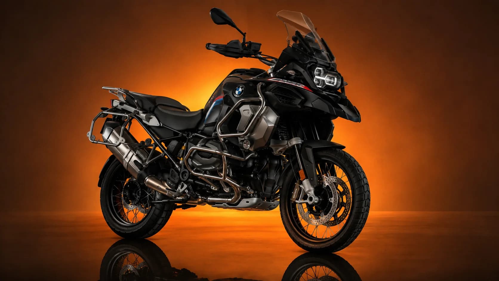BMW R1250GS Adventure noire et titane vue de trois quarts avant, sur fond ambré