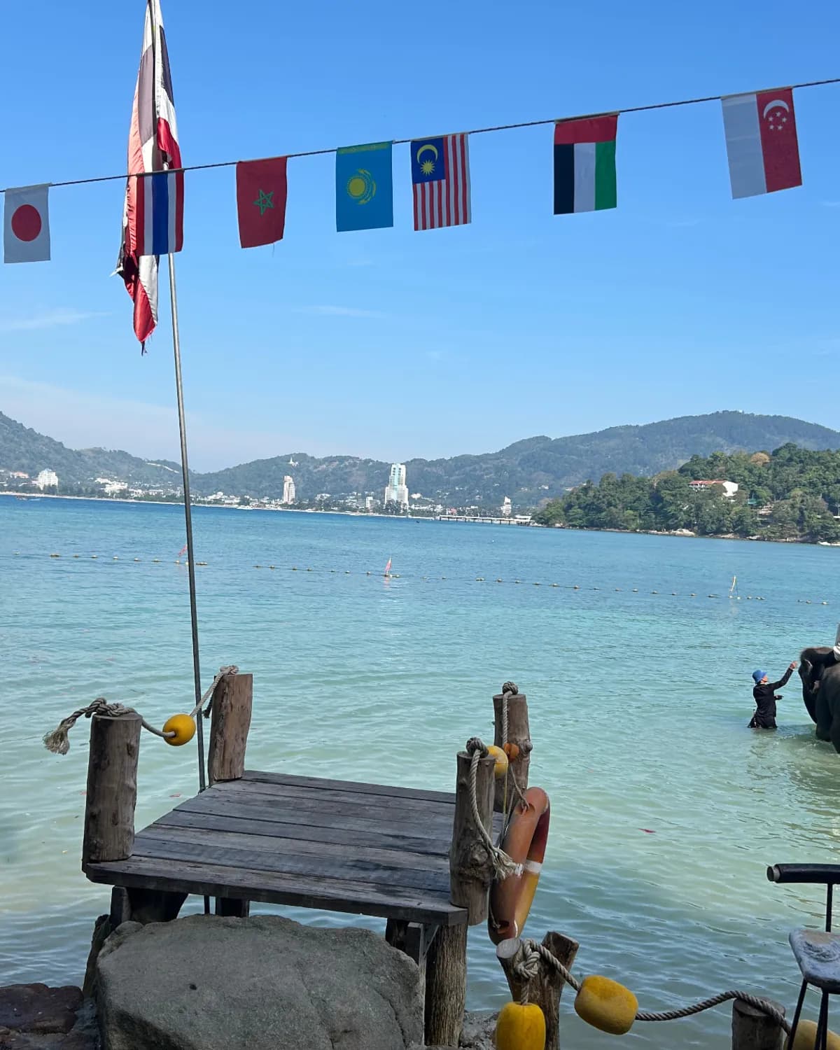 Ponton de bois sur une baie de Phuket, la ville au fond