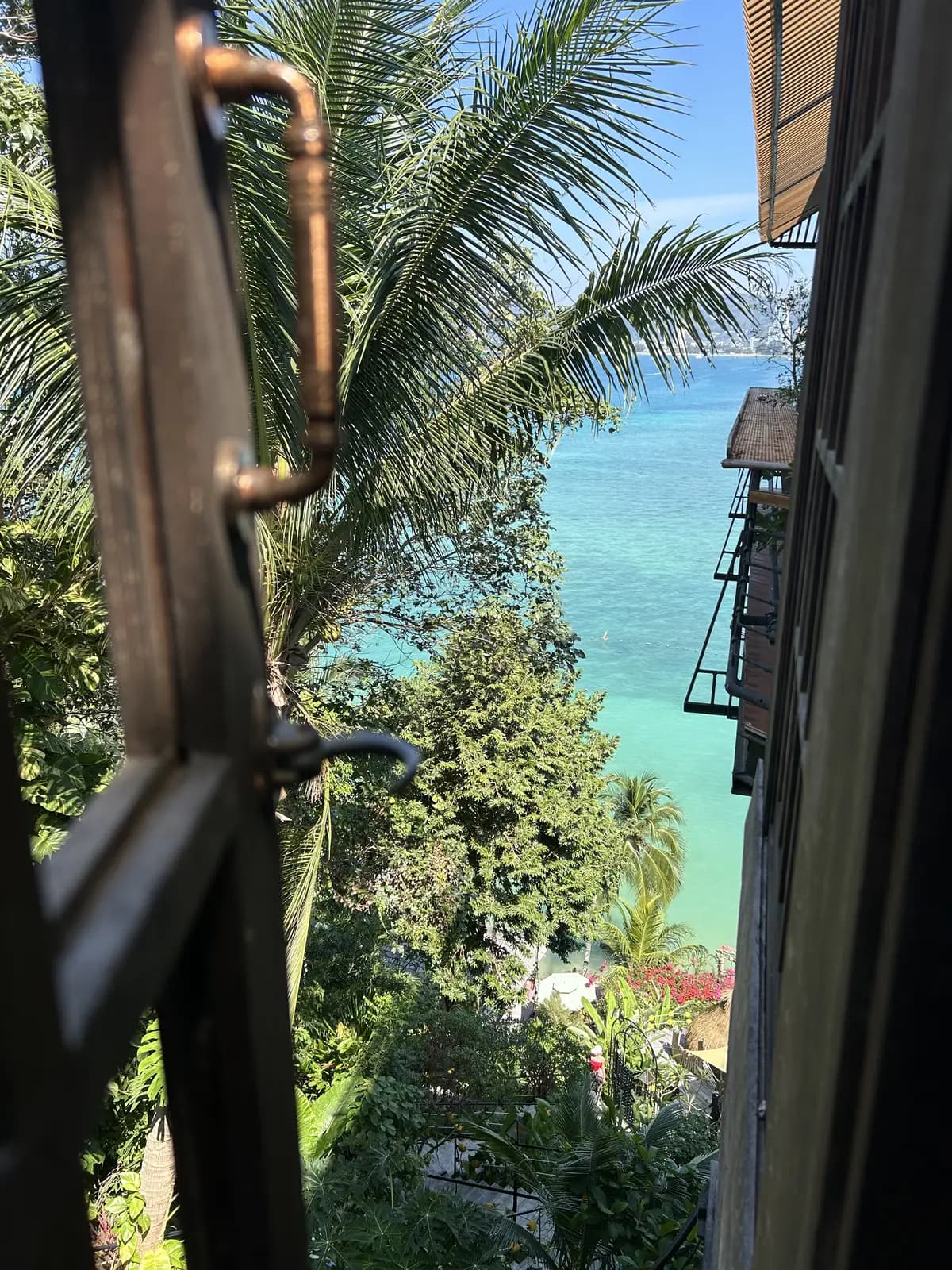 Terrasse en bois et métal d'une villa des hauteurs de Phuket, ouverte sur la jungle et la mer turquoise