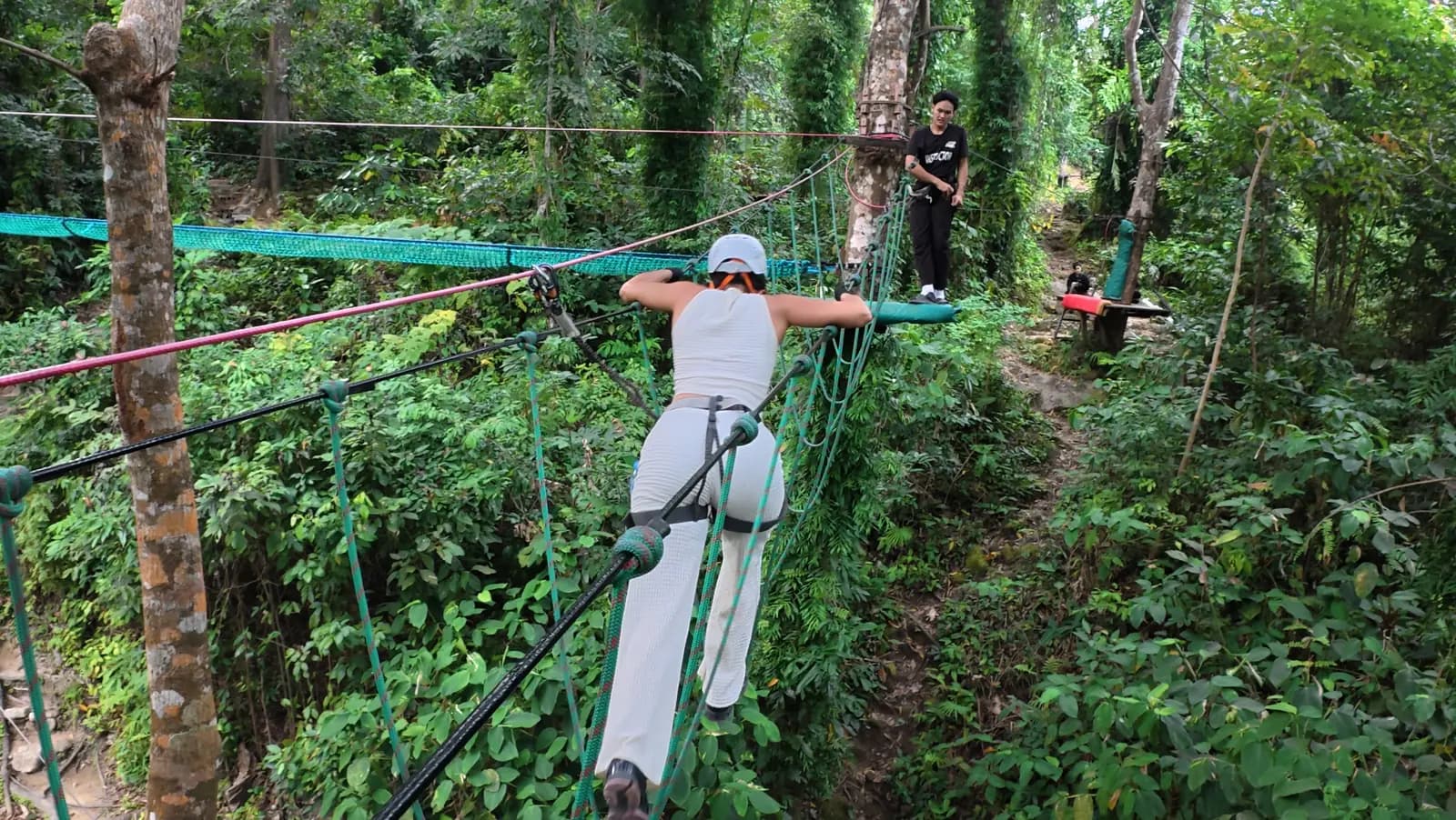 Personne suspendue à une tyrolienne au-dessus de la jungle, sanglée et casquée, dans l'intérieur de Phuket