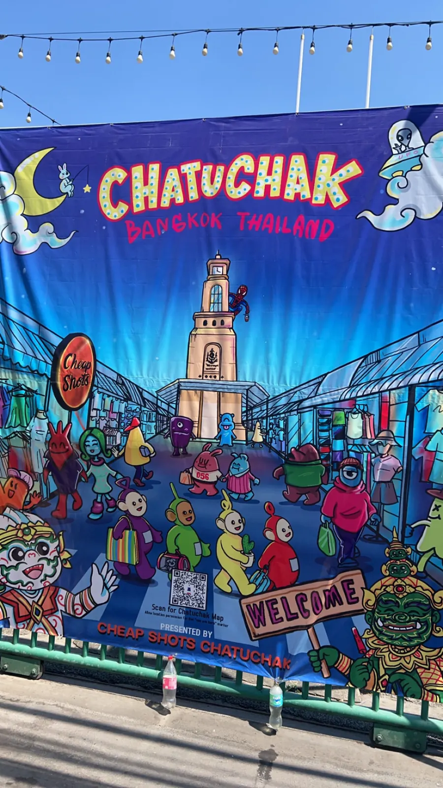 Banderole d'entrée peinte et colorée du marché de Chatuchak à Bangkok, tour de l'horloge au centre, échoppes de part et d'autre
